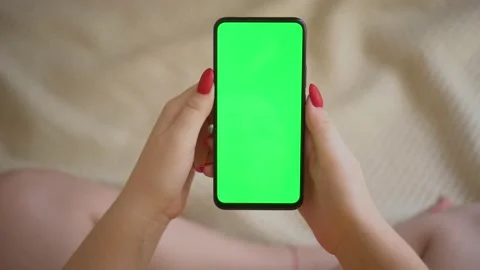 Back view over shoulder of young girl using smartphone with green screen sitting Stock Footage 142917093