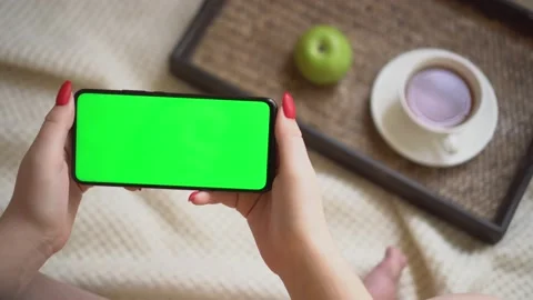 Back view over shoulder of young girl using smartphone with green screen sitting Video stock 142980950