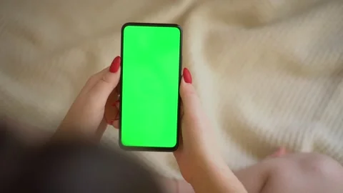 Back view over shoulder of young girl using smartphone with green screen sitting Stock Footage 143440991