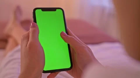 Back view over shoulder of young asian girl using smartphone with green screen Stock Footage 146167127