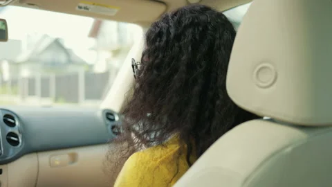 Back view of the overjoyed Afro American woman sitting at the passenger seat at Stock Footage 169751700