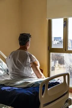 Back view of patient observing the outside world through a window Stock Photos