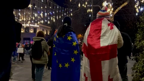 Back view. People with blue EU and Georgian flag on city street Stock Footage 298701775