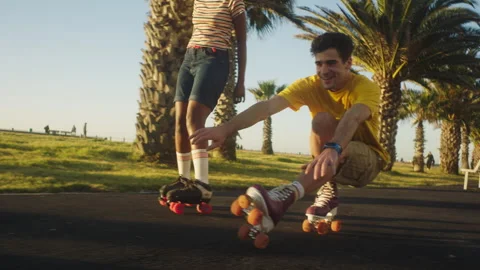 Back view of people rollerskating next to the palm trees on the street Stock Footage 279339264