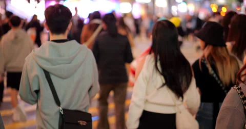 Back view of people walking across city street, slow motion waist-up shot Stock Footage 309401756