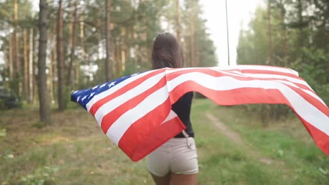 Back view Person Holding The Flag Of The Usa. Slow motion Stock Footage 123571913