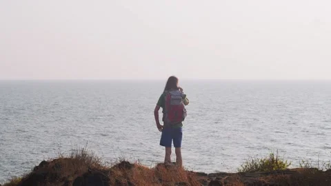 Back view portrait of tourist backpacker standing at sea ocean background copy Stock Footage 133913497