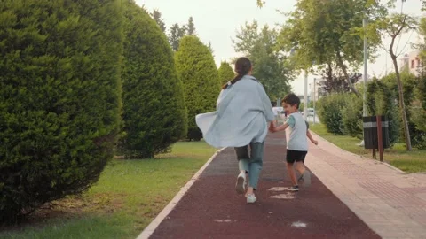 Back view of preschooler and mom running along the alley Video stock 201215759