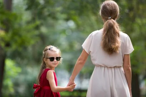 Back view of pretty small blond long-haired child girl in sunglasses and fash Stock Photos