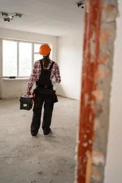 Back view of professional handyman or repairman standing on home holding his Stock Photos