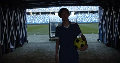 Back view of professional soccer player going to empty stadium with ball, man Stock Footage 139220202