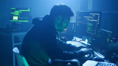 Back view of programmer coding technologies on computer in smoky office at night Foto stock