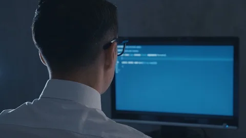 Back view of programmer professional in glasses programming code on computer Video stock 106212611
