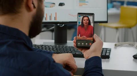 Back view of project manager holding smartphone listening remote leader Stock Photos