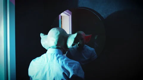 Back view of Psycho freak cleaning his hands with horror pig mask in front of Stock Footage 230235586