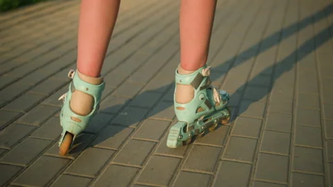 Back View of Roller Skating on Interlocked Brick Path with Shadow Cast Stock Footage 289099416