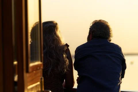 Back view of a romantic couple looking over a boat deck during sunset Fotos Stock