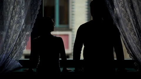 Back View of Romantic Couple Standing near the Window in the Darkness. Man is Ta Stock Footage 73670907