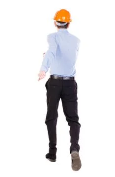 Back view of running engineer in helmet. Walking guy in motion Stock Photos