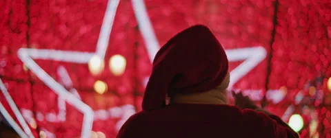 Back view of Santa Claus against the background of Christmas city decorations Stock Footage 141366280