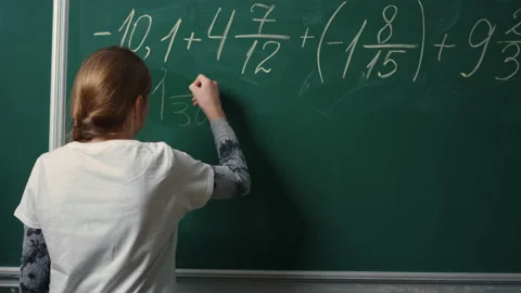 Back view of school girl doing math task on blackboard in class.Student writing Stock Footage 151369059