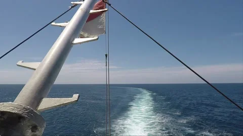 Back view to the sea from the stern of the ferry, the flag waving, Celebes Sea Stock Footage 144363335