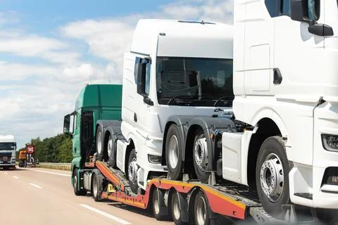 Back view of semi-trailer flatbed vehicle deliverying many new electric trucks Fotos de archivo
