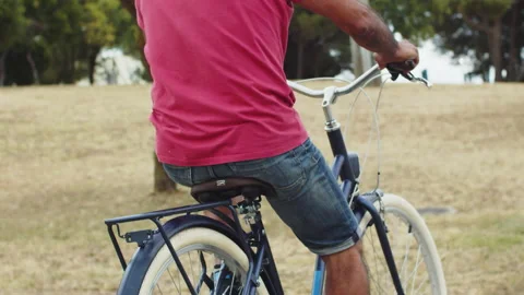 Back view of senior man riding bicycle in park 動画素材 159759635