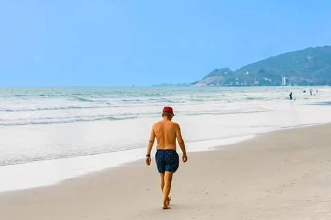 Back view of senior man walking on beach. Portrait happy senior man while w.. Stock Photos