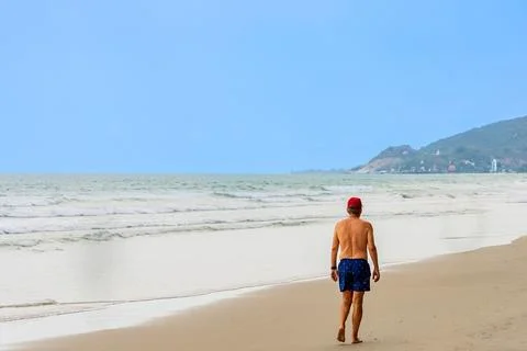 Back view of senior man walking on beach. Portrait happy senior man while w.. Stock Photos