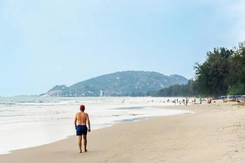 Back view of senior man walking on beach. Portrait happy senior man while w.. Stock Photos