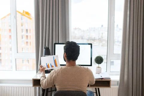 Back view of the serious concentrated determined young bearded office worker in Foto stock