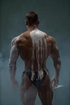 Back view of shirtless athletic strong man at studio Stock Photos