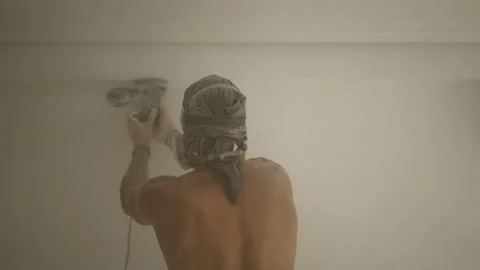 Back view of shirtless handyman performing wall smoothing at home Video stock 209596010