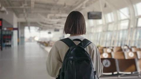 Back view of the short haired young woman walking through the empty airport with Stock Footage 153660237