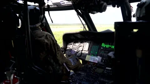 Back View Shot of a Military Pilot in a Blackhawk Helicopter Cockpit Vidéo 130361982
