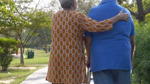 Back view shot of an old couple doing morning walk together in a hospital park Vidéo 124575374