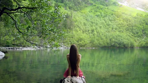 Back view shot of slim brunette woman raising arms in lotus pose while Stock Footage 162393233