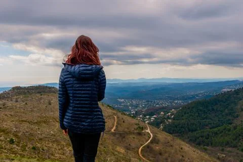 A back view shot of an unrecognizable  young redheaded woman standing enjoyin Stock Photos