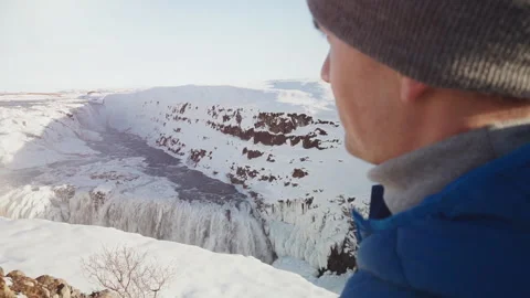 Back view shot of young man near the waterfall in Iceland Stock Footage 106191731