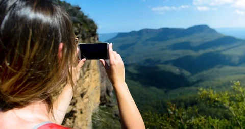 Back view shot of young  traveller woman making panoramic photo Stock Footage 128763534