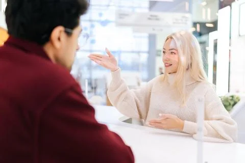 Back view from shoulder of unrecognizable man having conversation through glass Stock Photos
