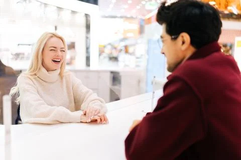 Back view from shoulder of unrecognizable young man chatting through glass Stock Photos