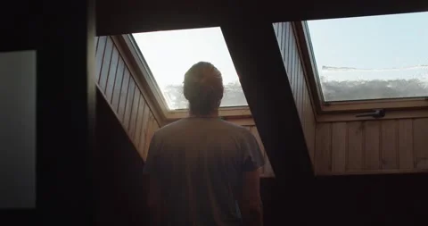 Back view silhouette of person admiring rising sun indoors slow motion Stock Footage 150608228