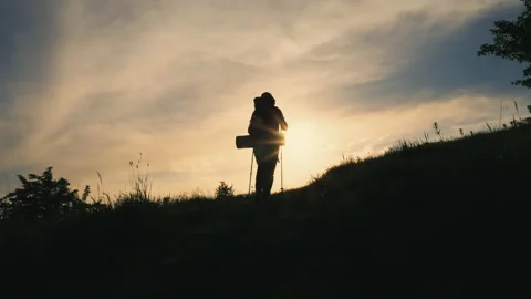 Back view silhouette of walking man with backpack on the mountain Stock Footage 154421745
