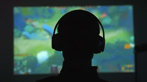 Back view of silhouette of a young man plays video games in dark room watches a Stock-Footage 108373401