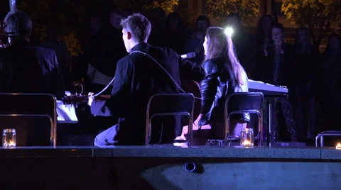 Back view singing playing music band in city center in evening . 4K Stock Footage 56453723