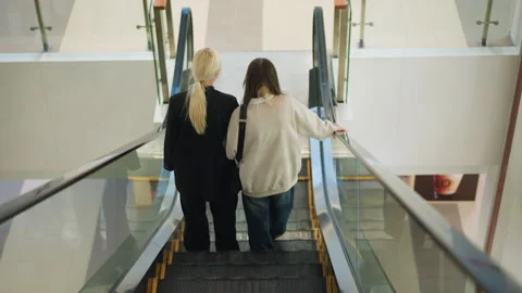 Back View of Sisters Descending Escalator in Mall Stock Footage 320133959