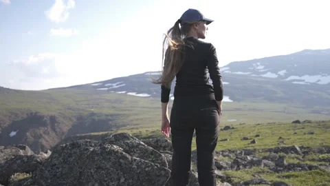 Back view of a slender girl looking at the mountains Stock Footage 137438806