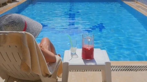 Back view of slim young woman relaxing near swimming pool. Stock Footage
